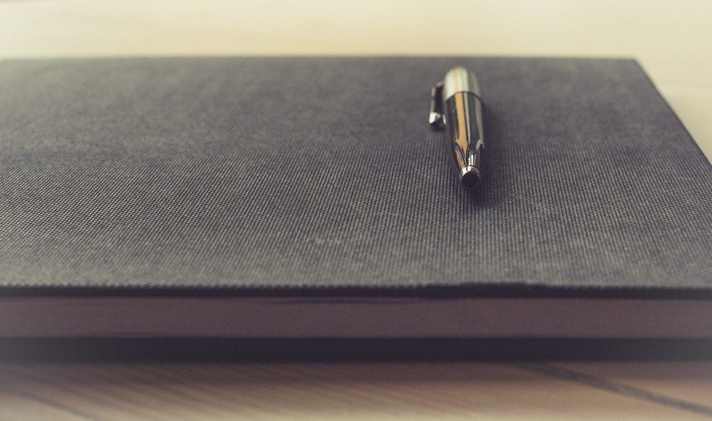 A paper notebook and pen used as a simple habit tracker
