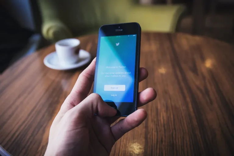 A hand holding a smartphone open to a social media app