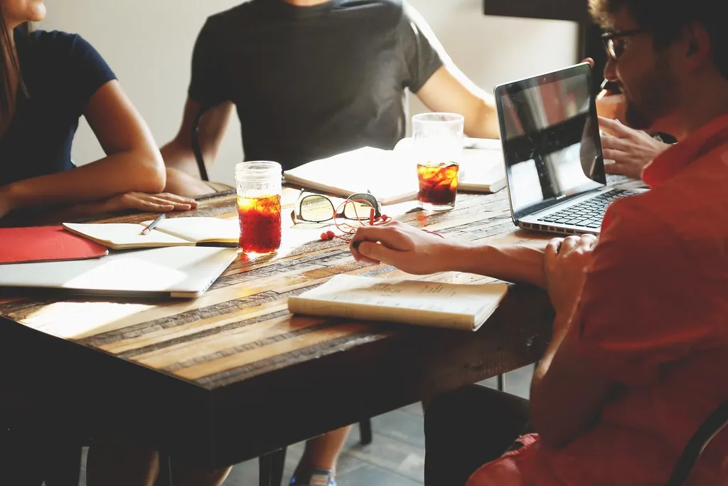 People working together at a table with a laptop