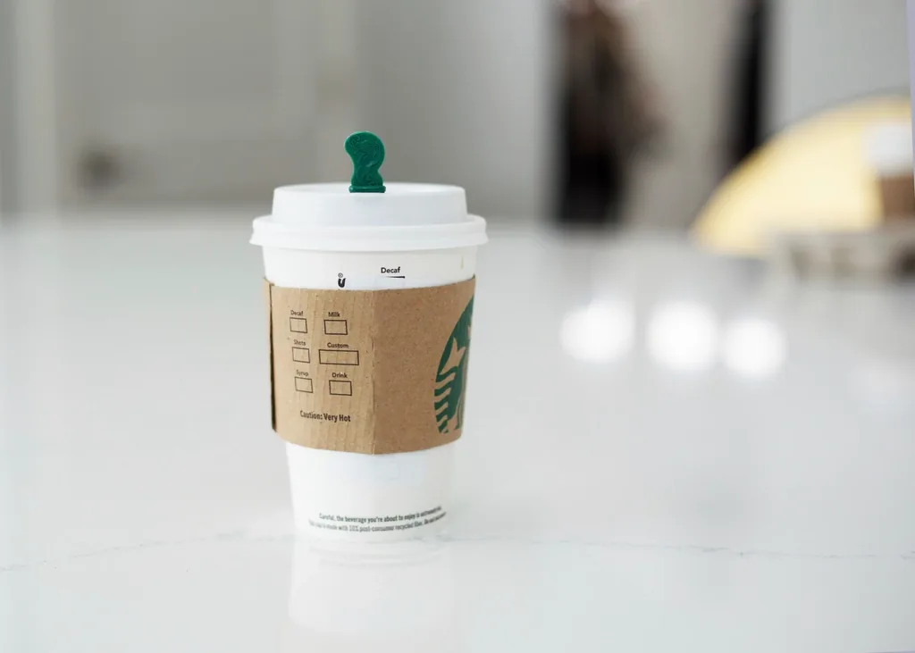 A takeaway coffee cup on a bright table, suggesting a calm morning