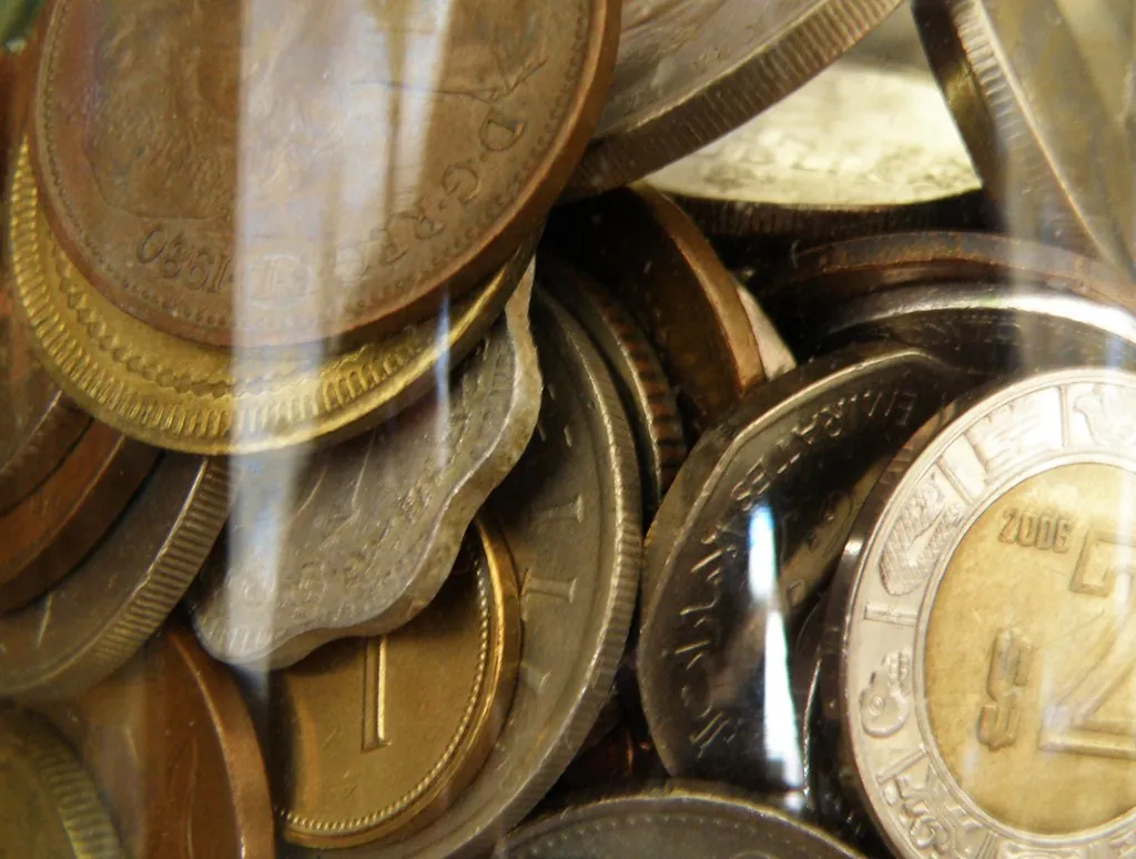 A jar filled with assorted coins, representing an emergency savings fund